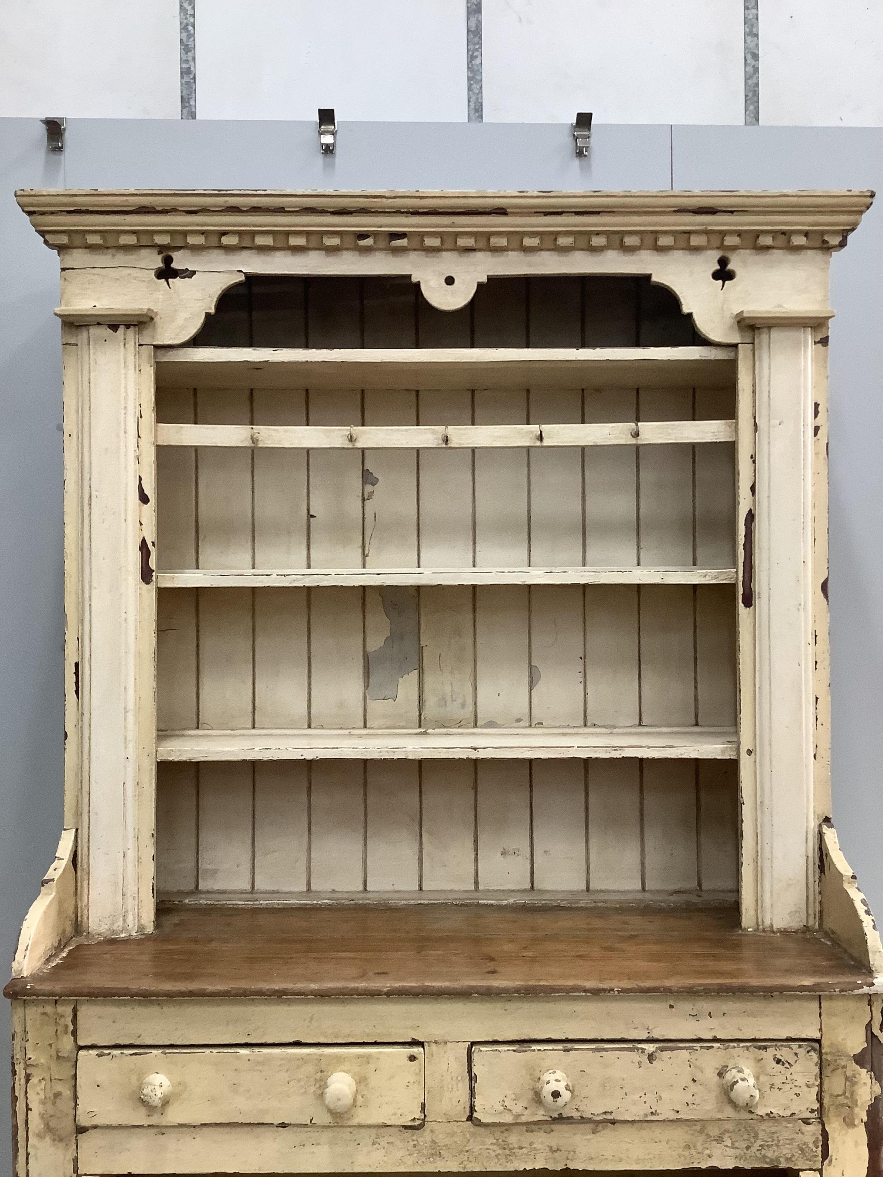 An early 19th century Irish painted pine dresser with boarded rack, width 126cm, depth 49cm, height 210cm. Condition - fair